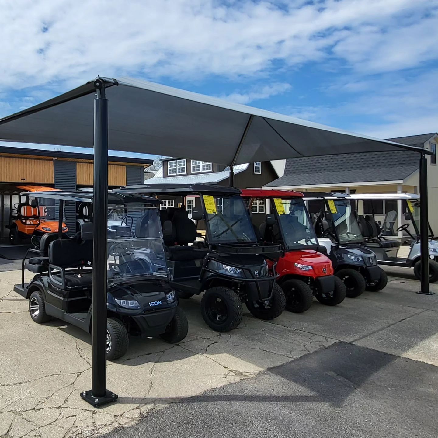 Golf carts lined up under the shade canopy